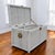 Vintage White Wicker Storage Trunk with Brass Hardware. A vintage woven wicker storage trunk in a painted white finish...