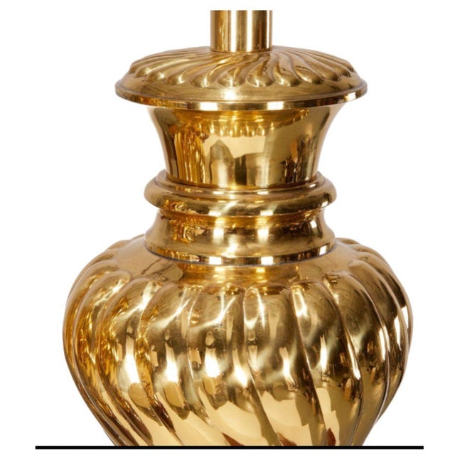 A vintage pair of Hollywood Regency style table lamps featuring a classic ginger jar inspired shape rendered in warm,...