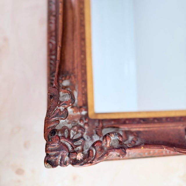 A beautifully detailed carved wood mirror with a warm copper-gold finish, hand-applied in an antiqued technique that...
