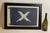Nautical flag in frame with glass. Blue flag with crossed feathered quills. Blue field with white applied letters. White...