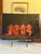 A charming original folk art painting depicting four vibrant red lobsters gathered together against a dramatic black...