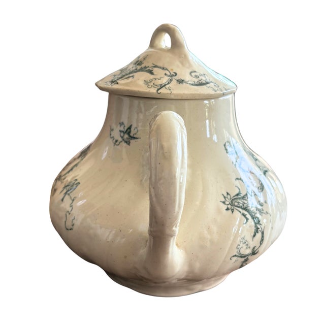 A beautifully rustic French faience teapot with its original lid, adorned with a delicate blue transfer decoration of...