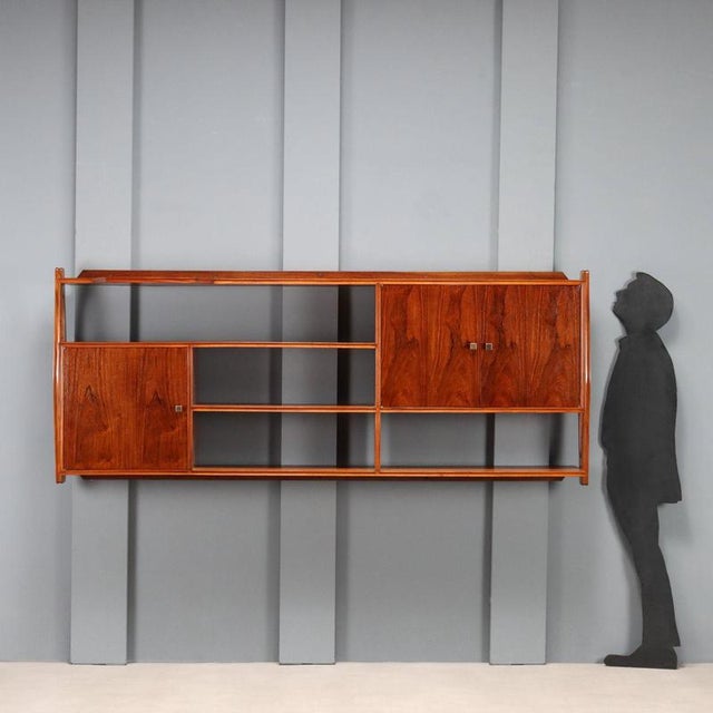 Wall-mounted cabinet with open compartments and storage compartments, one of which has a glass shelf. Made of wood with...