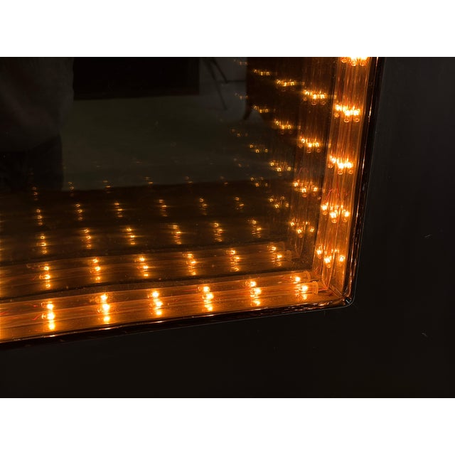 This wall-mounted infinity mirror creates the classic receding tunnel of light effect using amber bulbs set between two...