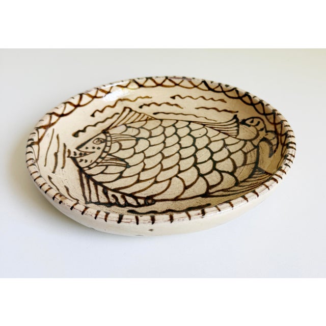 One round Tzintzuntzan plate, handmade and hand-painted in Michoacan, Mexico. The color palette includes a cream...