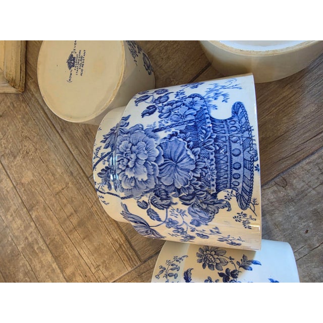 Four stunning English Staffordshire Crown Devon blue and white floral pattern decorated storage jars with wood lids. These...