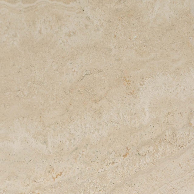 A striking Italian dining or center table crafted in solid travertine, showcasing the natural texture and tonal variation...