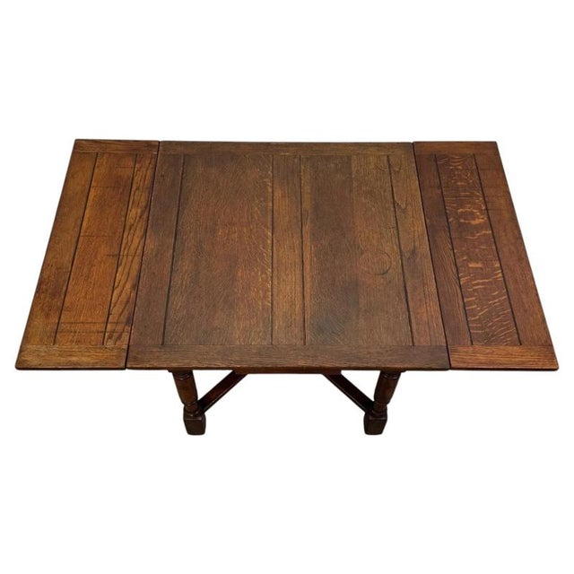 A handsome and well-crafted early 20th-century English Edwardian draw-leaf dining table, beautifully constructed in oak...