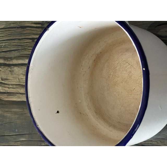 Vintage kitchenware white enamelled pot with cover and blue trim. Signs of use.