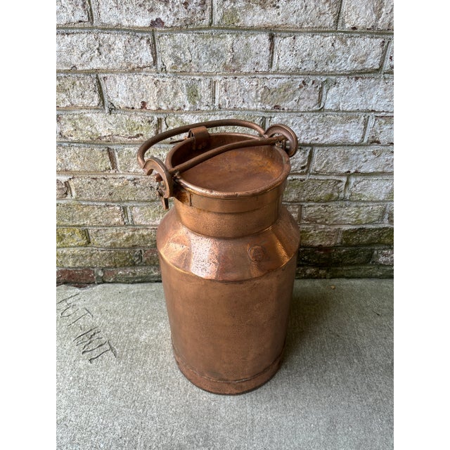 Antique lidded copper jug with handled lid. Patina and dents to copper can be seen throughout.