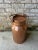 Antique lidded copper jug with handled lid. Patina and dents to copper can be seen throughout.