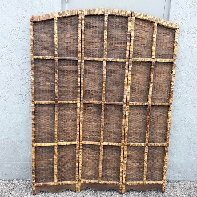 A beautifully textured vintage three-panel folding room divider crafted with densely woven natural wicker in warm honey,...