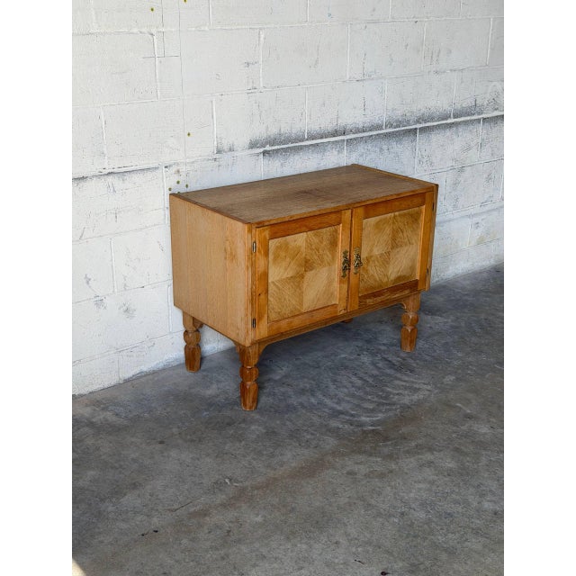 This versatile storage piece features two parquet paneled doors and an internal shelf for organization. Crafted in Denmark...
