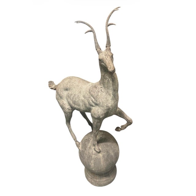 Perched atop a classic sphere and a stepped circular plinth, the piece exhibits an elegant, elongated silhouette...