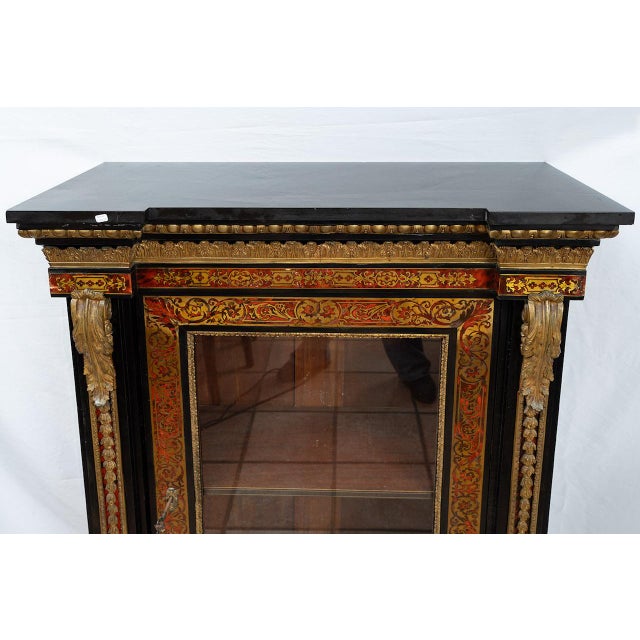 A Napoleon III-style Boulle display cabinet in ebonized wood and gilded bronze dating from the second half of the 19th...