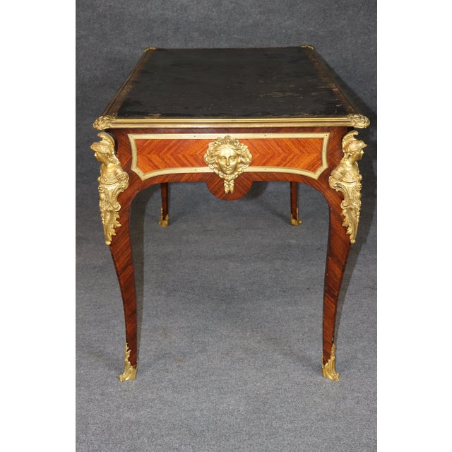This handsome French Louis XV-style bronze-mounted writing desk, dating from the late nineteenth to early twentieth...