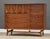 A mid century modern walnut eight drawer dresser credenza with swooping walnut and brass arch details made by Broyhill...