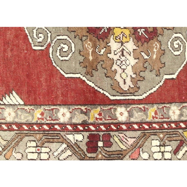 A handwoven wool rug from Turkey's Oushak region, measuring 3'6" x 5'3". This vintage piece showcases the region's...