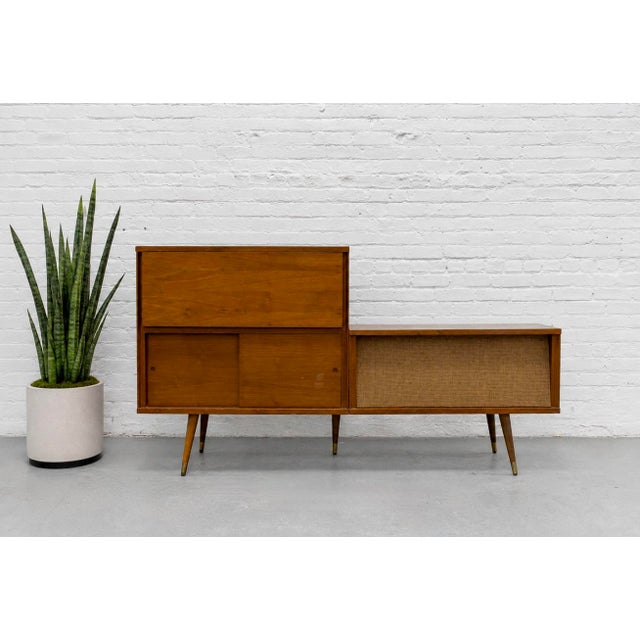Mid Century Modern vintage bar cabinet and stereo console, c. 1960’s. Featuring a beautifully balanced asymmetrical...