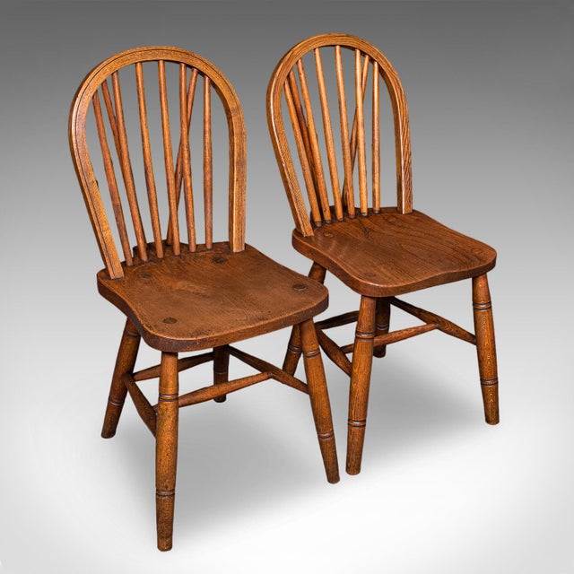 This is a set of four vintage side chairs. An English, ash and elm hoop back reception hall seat with military broad...