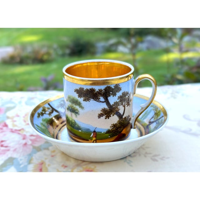 Antique Old Paris porcelain coffee cup and deep saucer, circa 1810–1820, with hand-painted pastoral landscape decoration...