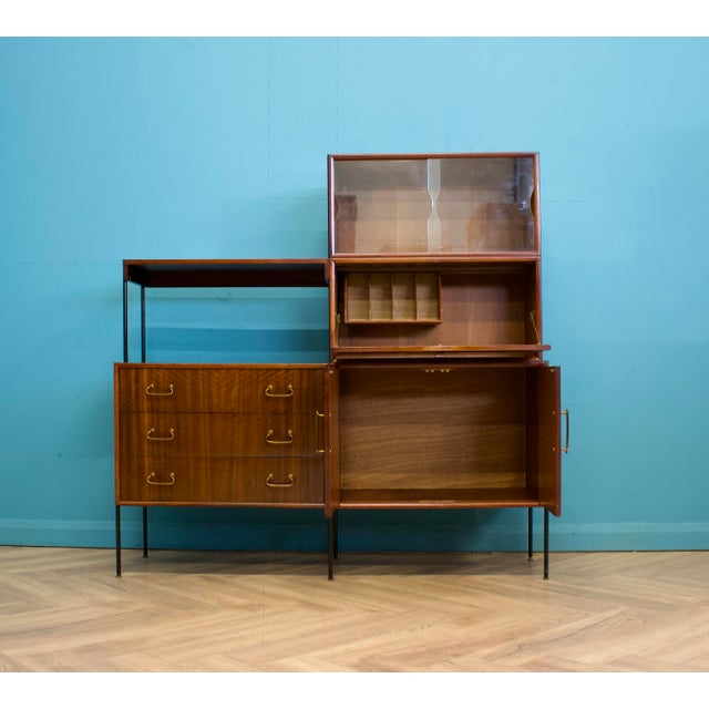 A mid century walnut sideboard shelving unit with a desk designed by Peter Hayward for Vanson, circa 1950 Featuring two...