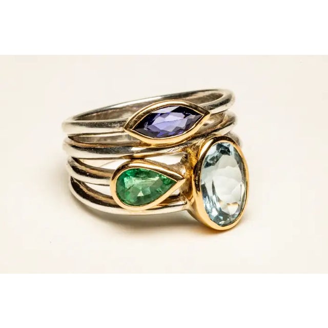A beautiful cluster ring of faceted gemstones--an oval aquamarine, a marquise cut amethyst and a pear-shaped green...
