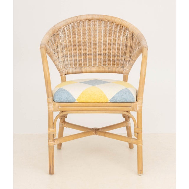 Modern Rattan Arm Chair, with diamond patterned blue, white, and yellow upholstered seat. 31" H x 21" W x 17" D; seat:...