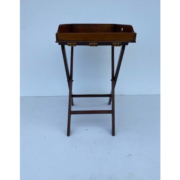 A mid-19th century English mahogany butlers tray on the stand features a rectangular tray with a surrounding gallery. On a...
