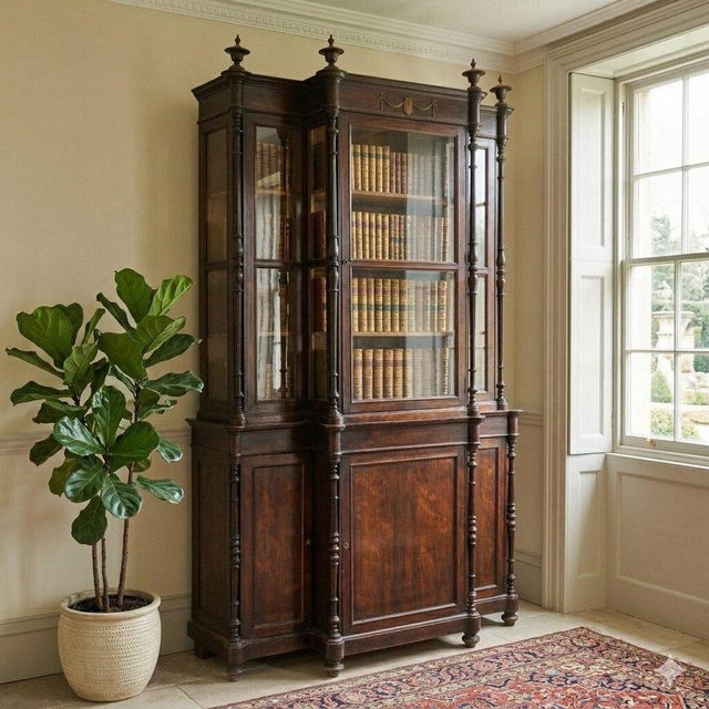 Antique bookcase. Structure with a projecting central element, a glazed upper section with two-part panels, a central...