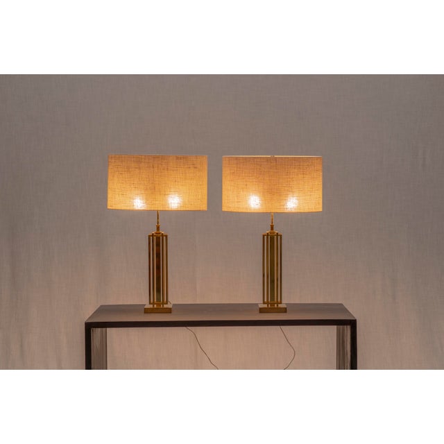 A striking and elegant pair of large French table lamps from the Hollywood Regency period, crafted in gilded brass. The...