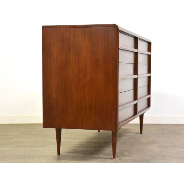 A mid century modern walnut six drawer dresser with wooden drawer pulls and dovetail joinery made by RWAY Furniture....