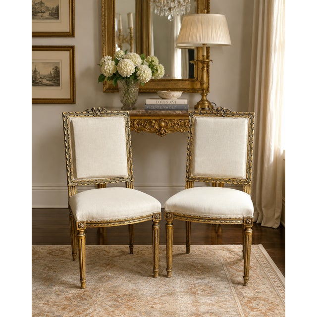 A sophisticated pair of mid-century Louis XVI–style giltwood side chairs, embodying timeless French elegance. Each chair...