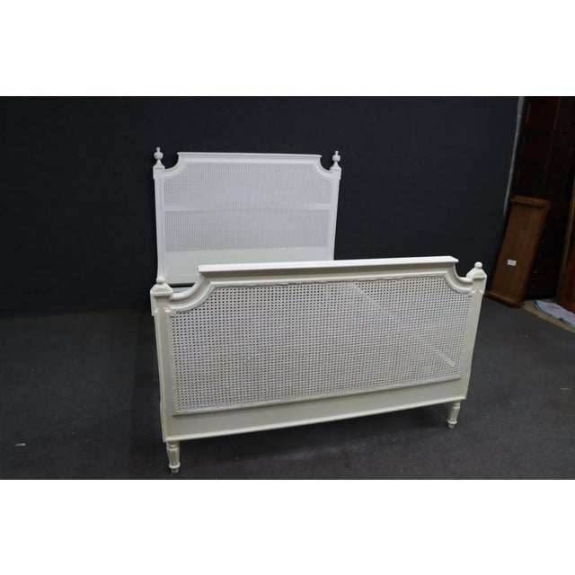 Ethan Allen French Provincial queen-size bed featuring an elaborate carved wood frame with woven cane panels. The...