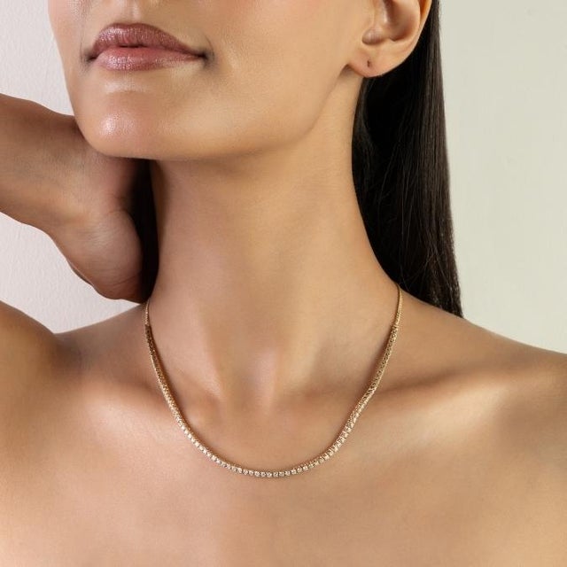 This elegant diamond tennis necklace features 85 round cut diamonds totaling 2.89 carats, set in 14K yellow gold. Each...