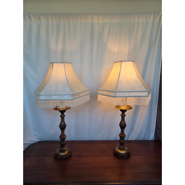 This matching pair of vintage table lamps showcases classic turned wood craftsmanship paired with warm brass accents and...