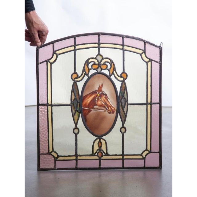 Gorgeous Art Deco stained glass window panel, featuring an exquisite, central hand-painted oval medallion of a horse in...