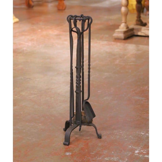 Decorate a hearth with this elegant hand-forged iron serviteur de cheminée crafted in France, circa 1960. The five-piece...