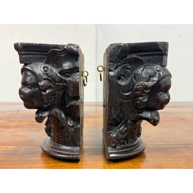 Design Plus Gallery presents a Pair of Carved Wood Capitals from the 18th Century. The capitals are carved with a dark...