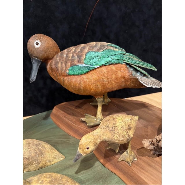 Vintage American folk art sculpture featuring a hand-carved and painted wooden duck family, mounted on a shared wooden...