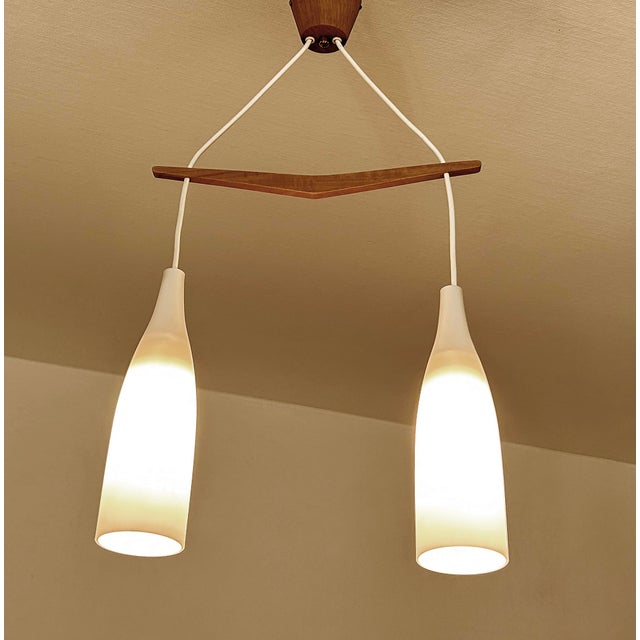 Mid century danish modern pendant light featuring a v shaped teak wood suspension and 3 opaline glass shades very good...