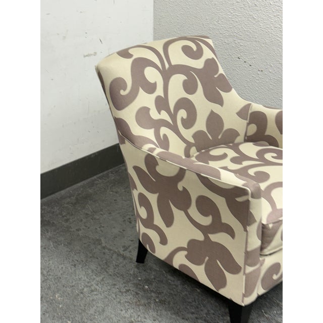 Design Plus Gallery presents the Clara Chair from Crate & Barrel. This upholstered chair displays a gently curved barrel...