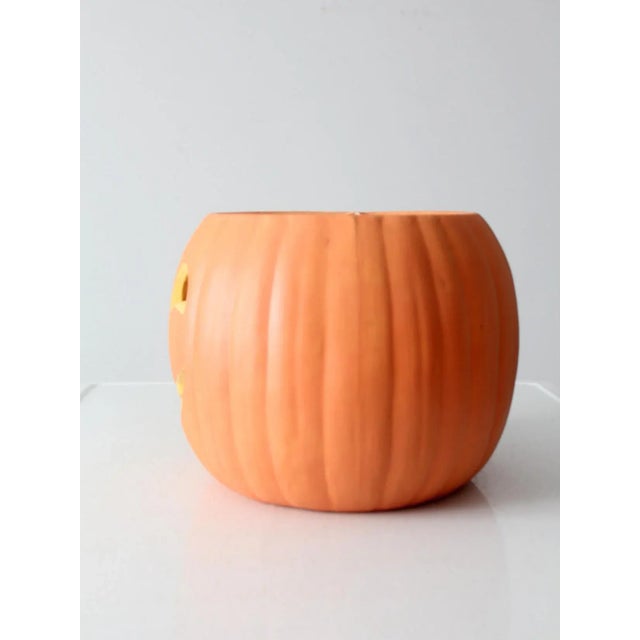 Brighten up your Halloween decor with this vintage ceramic jack-o-lantern. Adorned with a cheerful orange "carved" pumpkin...