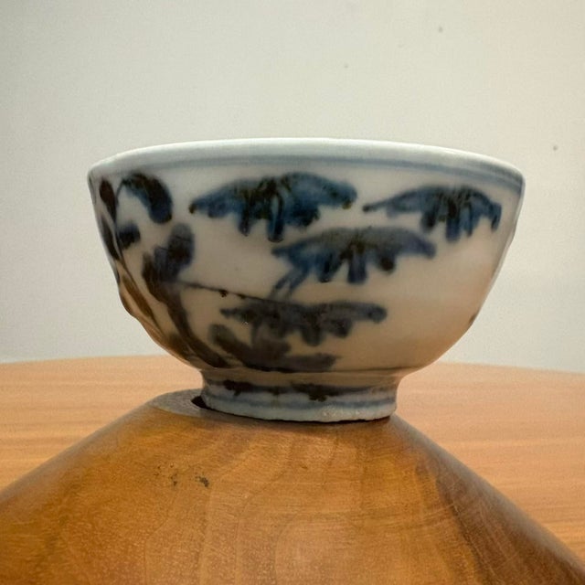 A beautifully hand-painted blue and white porcelain tea bowl, likely dating to the Qing Dynasty (late 17th to early 18th...