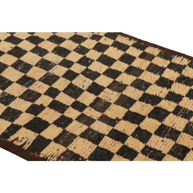 Hand-knotted in wool and originating from Morocco circa 1950-1960, this 3x6 vintage runner rug is a rare and among the...