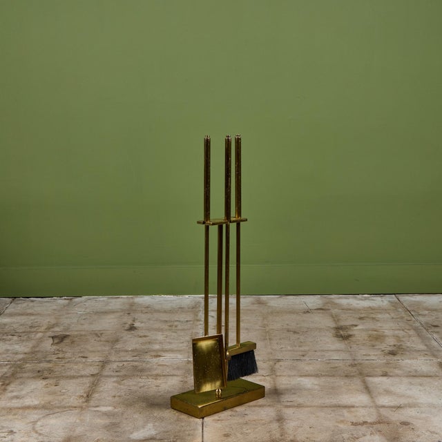 Three piece set of brass fireplace tools with stand. The set features three tools, shovel, broom and poker, all set on a...