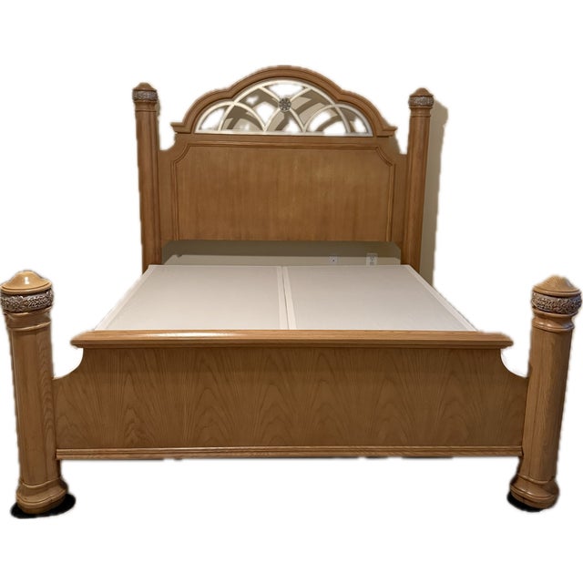 The king size bed has a tall arched headboard with decorative inset panels resembling a fan or sunburst design. Four...