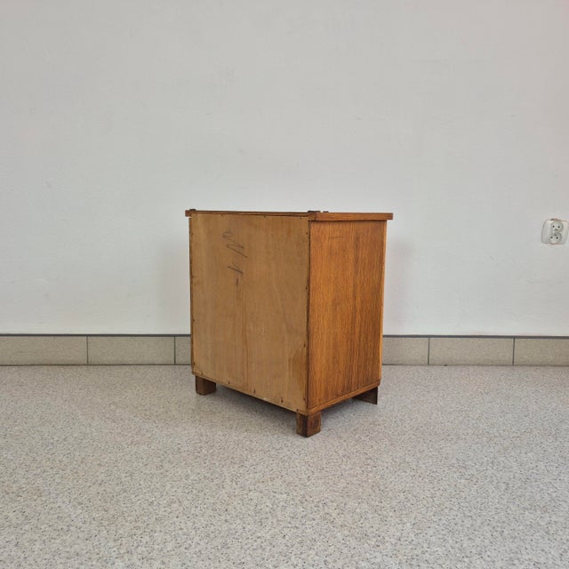 A charming small cabinet crafted in the style of late Art Deco, featuring elegant proportions and a beautiful combination...