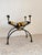 A stunning chair with a sculptural design, featuring a refined wrought iron frame, turned ends, brass details, and a...