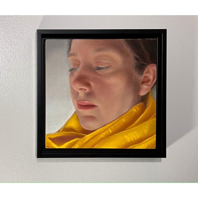 This intimate oil painting captures a serene moment, focusing on a figure enveloped in a vibrant yellow scarf. The soft,...